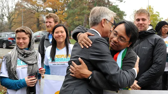 LWF general secretary Rev. Dr Martin Junge greets climate campaigner Yeb SaÃ±o as SaÃ±o and 17 other pilgrims arrive in Geneva on a march from Rome to Paris to push for a new climate deal. Photo: LWF/S. Gallay