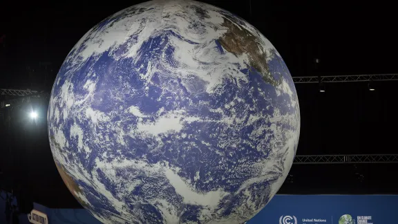 Eine große Weltkugel, die während der UN-Klimakonferenz COP26 in Glasgow von der Decke hing. Foto: LWB/Albin Hillert