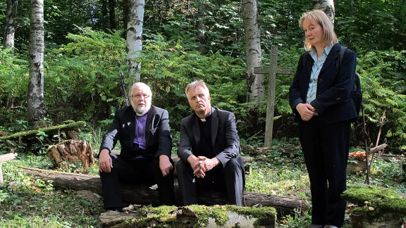 Visiting Keltto cemetery near St Petersburg: (left to right) ELCIR Bishop Arri Kugappi, LWF General Secretary Rev. Martin Junge and Europe Area Secretary Rev. Dr Eva Sibylle Vogel-Mfato at Keltto cemetery, a safe worship space for Ingrian Christians during Communist rule. Photo: Pekka Mikkola/FELM