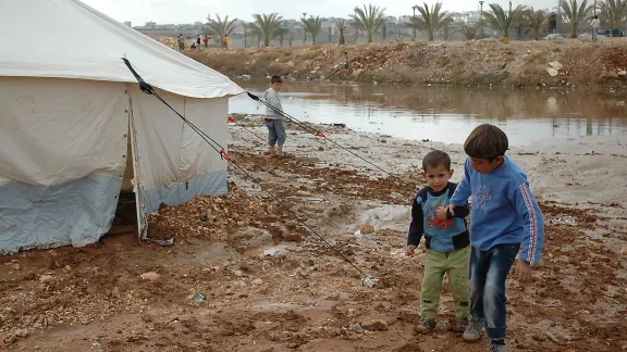 Children walk near flooding in tented settlement Jordan. Photo: Karl Schembri/Oxfam (CC-BY-NC-SA)