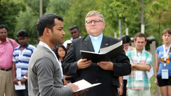 Caption: Benison Kachhap contemplates the significance of being the first young Lutheran to plant a tree in the renowned Luther Garden, in Wittenberg. Rev. Hans Kasch, director of the LWF Center in Wittenberg, looks on. Photo: GNC/LWF/F. HÃ¼bner 