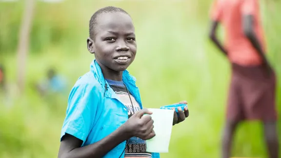 Ein junger südsudanesischer Flüchtling in Norduganda mit einer Schale Brei. Foto: LWB Uganda