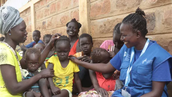 Sarah Ewoi, with a South Sudanese refugee family at Nadapal center. Photo : LWF Kenya