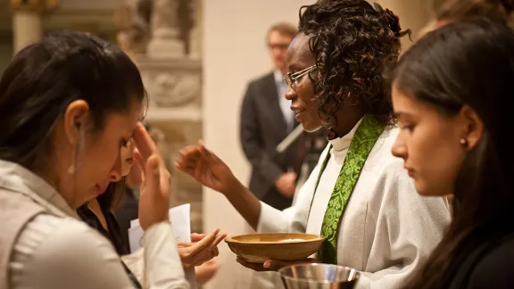 Die lutherische Pfarrerin aus Namibia, Lyauvika Nashuuta, teilt beim Abschlussgottesdienst vom Workshop des „Global Young Reformers‘ Network“ das Abendmahl aus. Der Workshop fand 2015 in Wittenberg, Deutschland, statt. Foto: LWB/Marko Schoeneberg