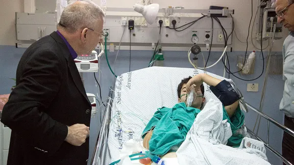 Bischof Munib Younan spricht mit einem verletzten Jungen auf der Intensivstation des St. Joseph‘s-Krankenhaus. Foto: D. Hudson/ELKJHL