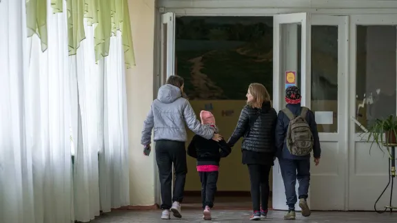 Schülerinnen und Schüler treffen in der Schule von Vasilchenko ein. Der Unterricht findet zwar nicht vor Ort statt, aber die Kinder kommen gelegentlich vorbei, um zum Beispiel Lernmaterial abzuholen. Foto: LWB/Abin Hillert