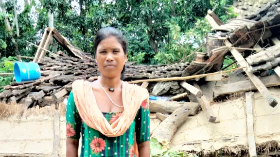 Rekha Chaudhary vor ihrem von Überschwemmungen beschädigten Haus. Foto: LWB Nepal