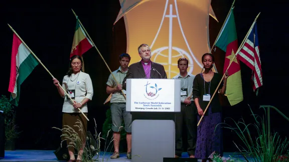 Benny Sinaga holding a flag as a youth delegate at the opening of the LWF Assembly in Winnipeg, Canada. Photo: Private