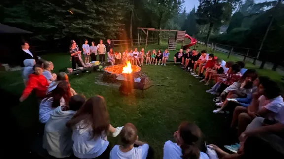 Teenagers around a campfire in the Wisla mountains. Older children in particular benefitted from the opportunity to spend time away from home and with peers . Photo: LWF Poland