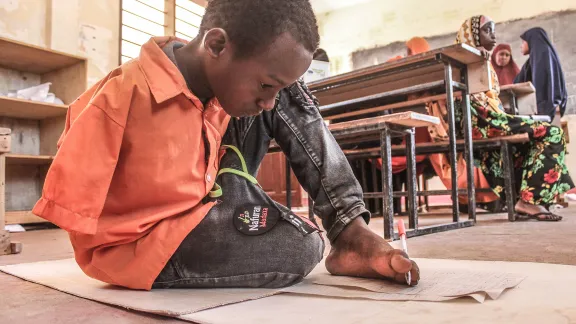 Mohamed has learned to draw with his feet. Photo: LWF/ N. Tado