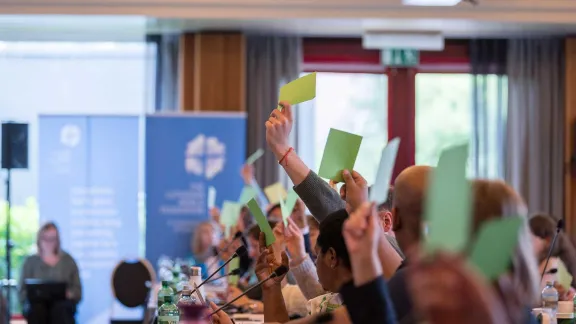 Miembros del Consejo levantan tarjetas verdes para votar la aprobación de una nueva estrategia de la FLM para el periodo 2025-2031. Foto: FLM/Albin Hillert