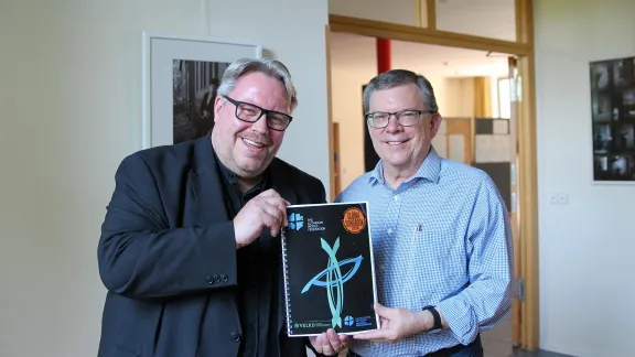 Dr. Uwe Steinmetz, der das Projekt seit 2019 leitete, und Prof. Dr. Dirk Lange, stellvertretender Generalsekretär des LWB für ökumenische Beziehungen, zeigen den Prototyp des neuen Global Songbook. Foto: LWB/A. Weyermüller