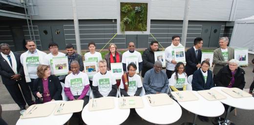 An interfaith group of religious leaders sits in front of empty trays during a public action promoting the Fast for the Climate campaign during the COP21 UN climate summit in Paris, France. Photo: LWF/R. Rodrick Beiler