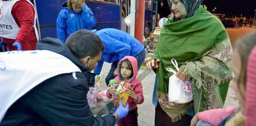 Staff from ACT Alliance member Hungarian Interchurch Aid offer food to a young refugee at Beremend, along Hungary's border with Croatia. Hundreds of thousands of refugees and migrants flowed through Hungary in 2015 on their way to western Europe from Syria, Iraq and other countries. Photo: Paul Jeffrey/ACT