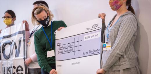 Representatives of faith-based organizations including the ACT Alliance, the LWF and Christian Aid take a stand for just financing at COP26 in Glasgow. Participants presented a large cheque supposedly signed by âRich Countriesâ promising to deliver âEmpty Promises Onlyâ to developing countries, as a sum of âUSD Blah Blah Blahâ. Photo: LWF/Albin Hillert