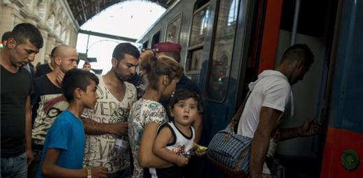 A refugee woman carrying a child prepares to board a train for northern Europe at Budapest's main station, Keleti.Photo: MTI