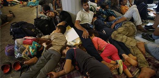 Refugees lie exhausted in a public place in Hungary, en route to northern European countries. Photo:MTI