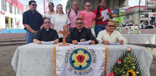 The leadership of the Honduran church presenting the 2019 general assembly statement in front of the Martin Luther bust in Tegucigalpaâs public square.  Photo: Roger Rivas
