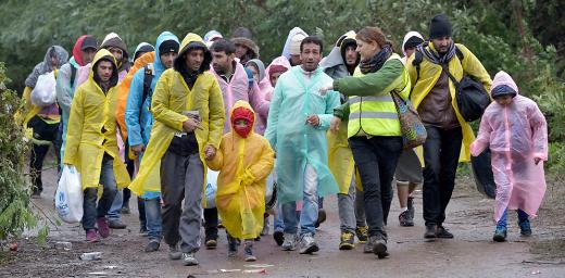 Escorted by a Czech volunteer (in the high-visibility vest), refugees approach the border into Croatia near the Serbian village of Berkasovo. Photo: Paul Jeffrey