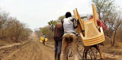 A refugee carts goods toward Uganda
