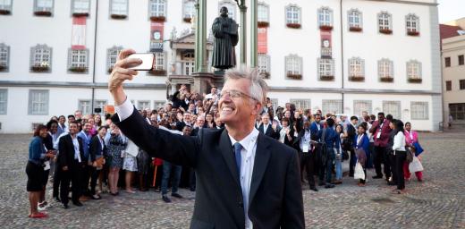 LWF General Secretary Martin Junge taking a selfie of himself, the old reformer Martin Luther and the young reformers on a square in Wittenberg. Photo: LWF/Marko Schoeneberg