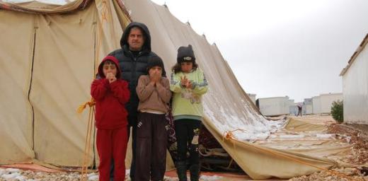 A street leader with his children in front of a half collapsed tent which is used as a Mosque. Photo: LWF/ J. Pfattner