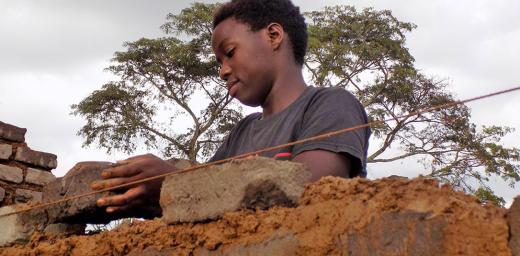 Hawa Andrew constructs a wall. Photo: LWF/ S. Nalubega