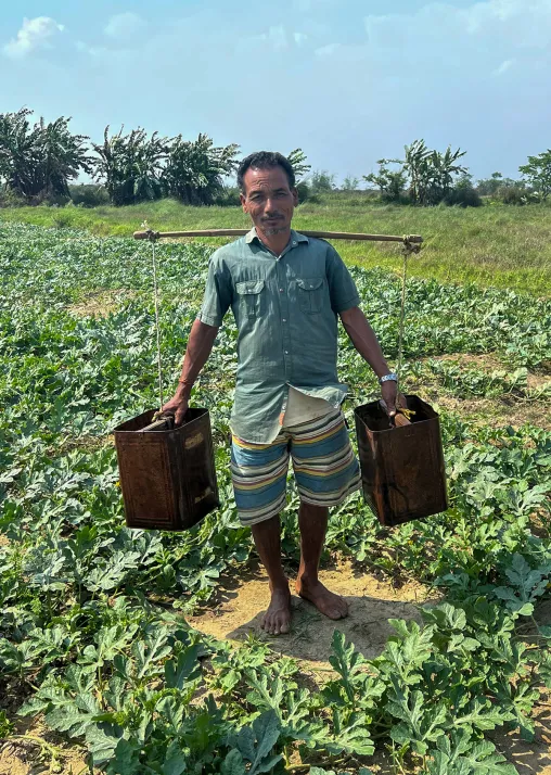 A farmer in Morang district showing labor-intensive irrigation in riverbed farming. Photo: LWF/ S. Muis